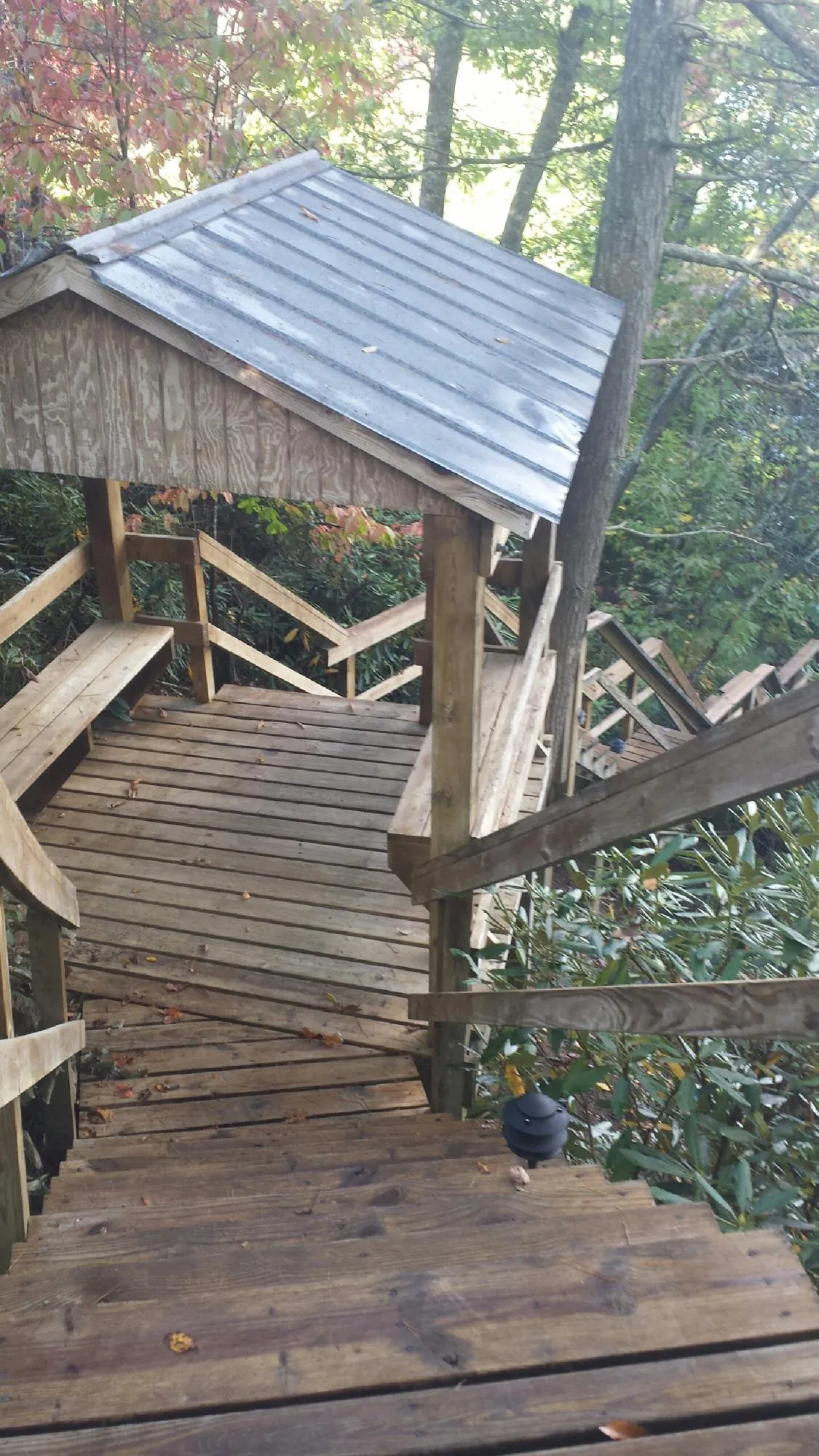 Metal roofed shelter over wooden steps on a wooded walkway — Skylight Repair & Installation work by our crew in Darien