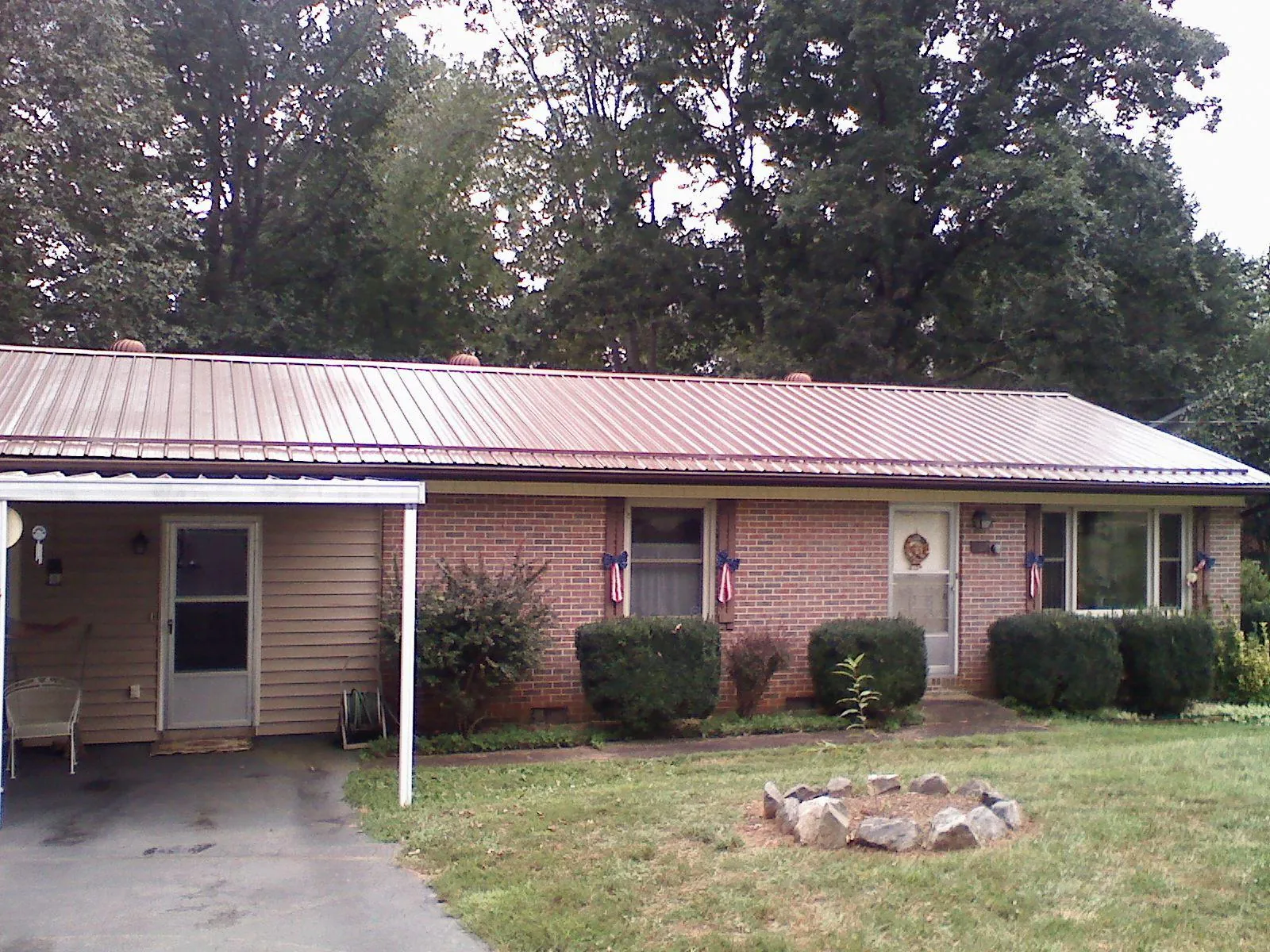 Bronze metal roof and carport on a brick ranch home — Roof Repair work by our crew in Darien